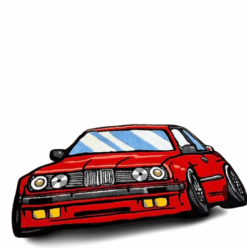Ein handgefertigter, roter Teppich mit einem cartoonartigen Auto liegt auf hellem Holzboden. Das frontal dargestellte Auto besticht durch klare Linien, satte Farben und Details wie Scheinwerfer und Reifen.