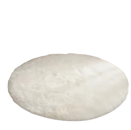 Der runde, weiße Flauschteppich verleiht dem Raum eine gemütliche Atmosphäre. Umgeben von Sofa, Pflanze und Deko im skandinavischen Stil, sorgt er für Wärme und Eleganz auf dem hellen Holzboden.